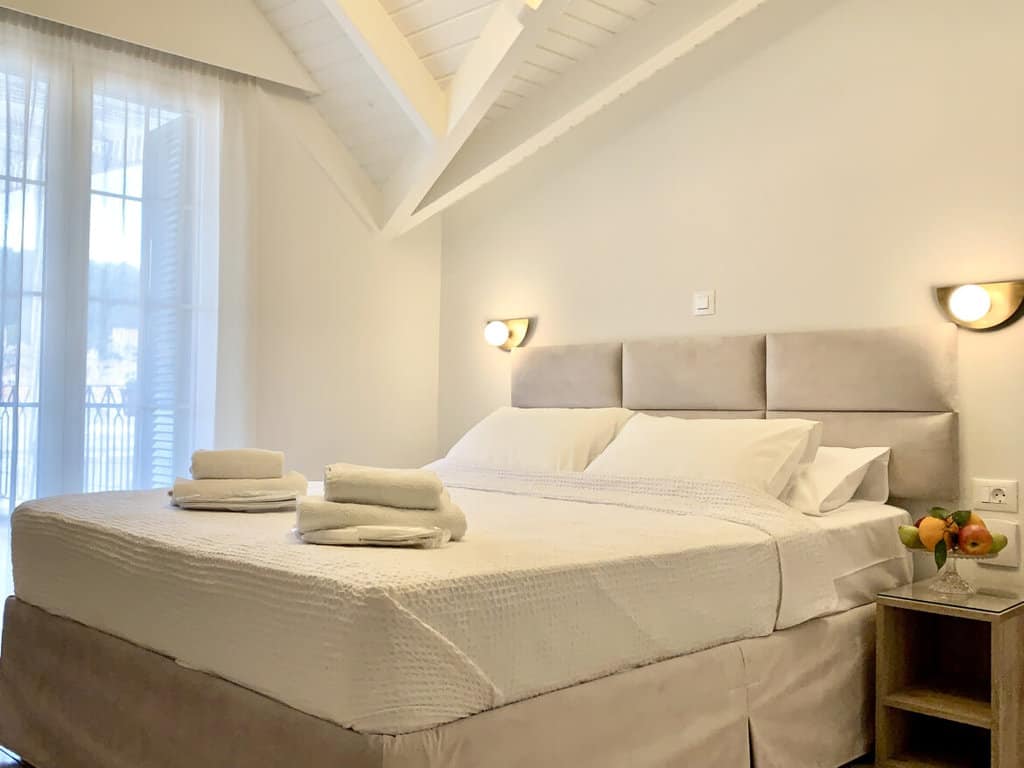 Elegant bedroom featuring a cozy Queen size bed with white sheets in Luxurious Apartment C1
